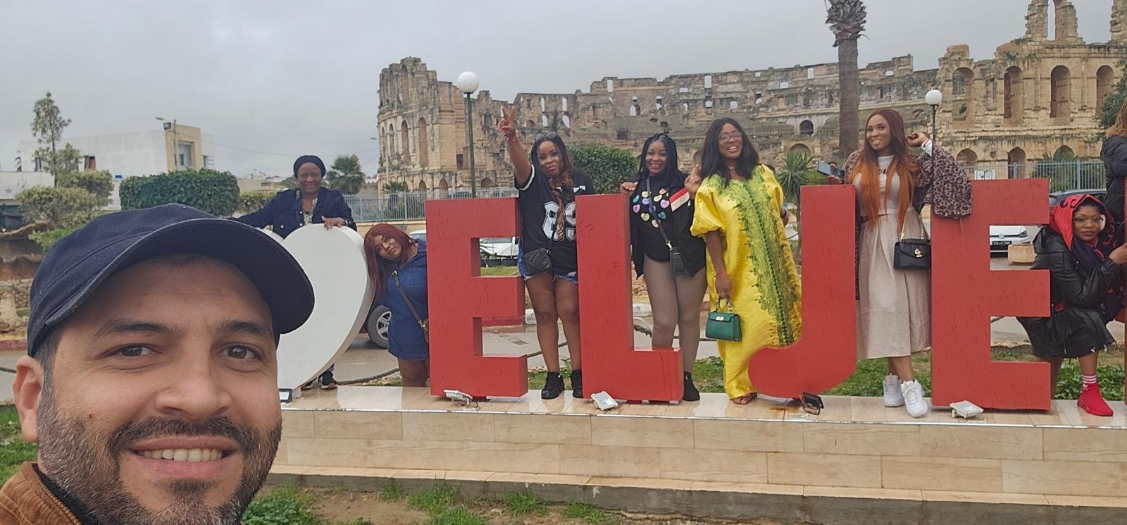Group selfie in front of the El Jem amphitheatre sign